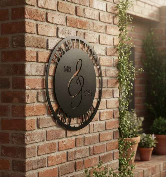 Decorative metal wall art with 'MR & MRS' on a brick wall.