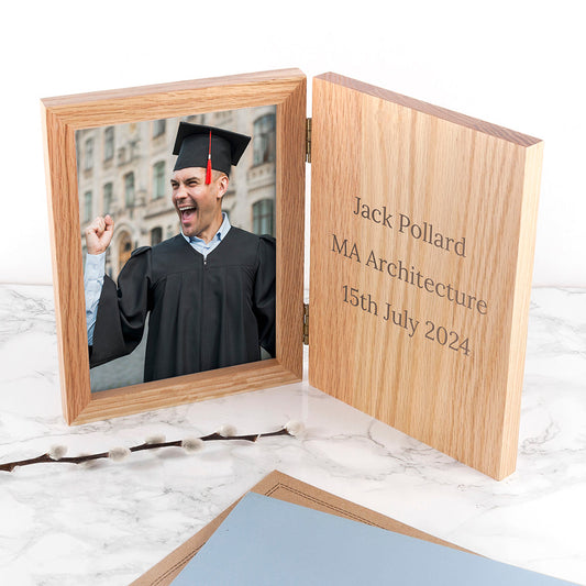 Wooden photo frame with a picture of a graduate and engraved text on a marble surface