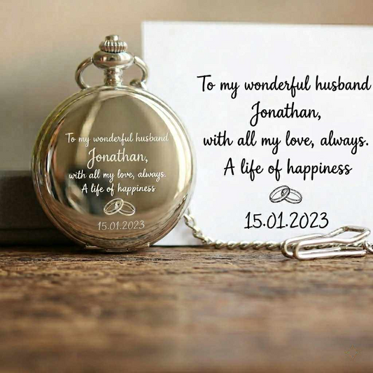 Silver pocket watch with engraved message on a wooden surface