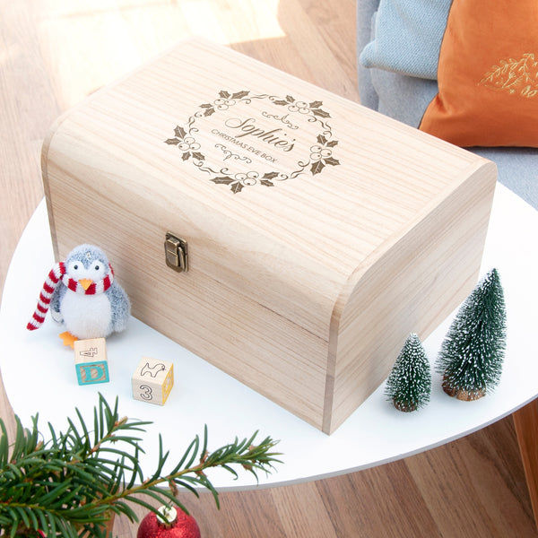 Wooden box with engraved text on a table with decorative items