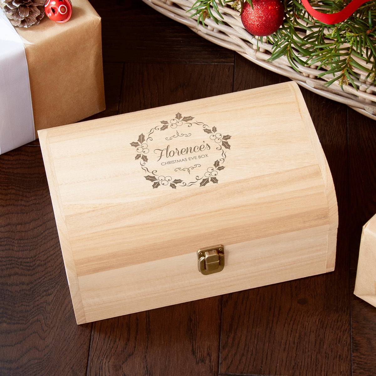 Wooden Christmas Eve box with engraved design on a wooden surface with festive decorations.