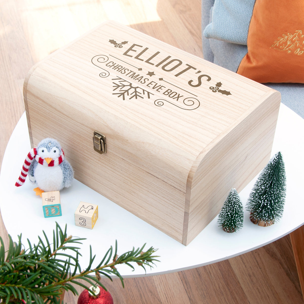 Wooden box with engraved text on a table with Christmas decorations
