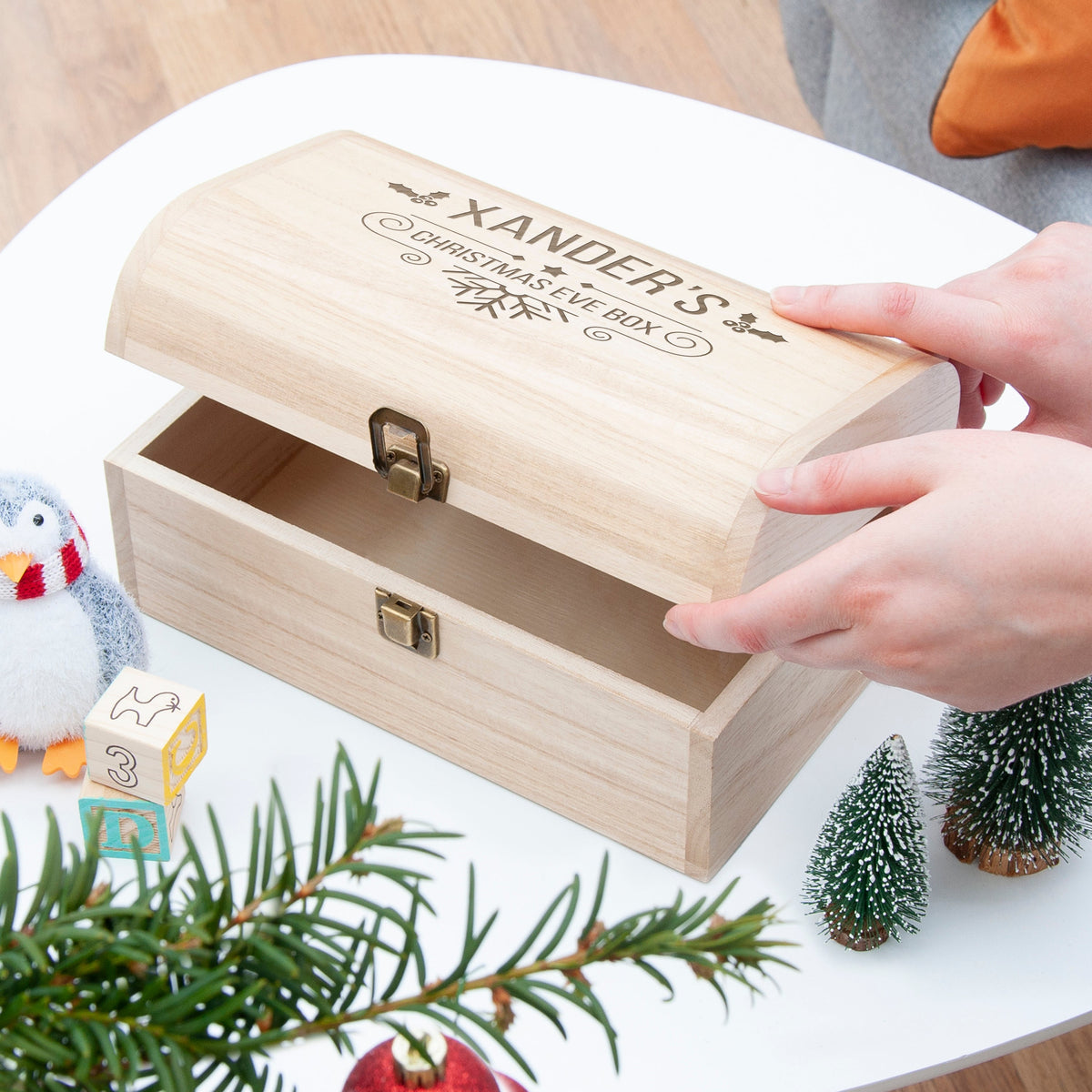 Wooden box with engraved design on a decorative surface with Christmas elements