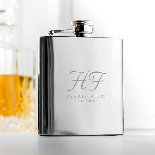 A polished stainless steel 6oz graduation hip flask custom-engraved with a graduate's initials, course name, and graduation date.