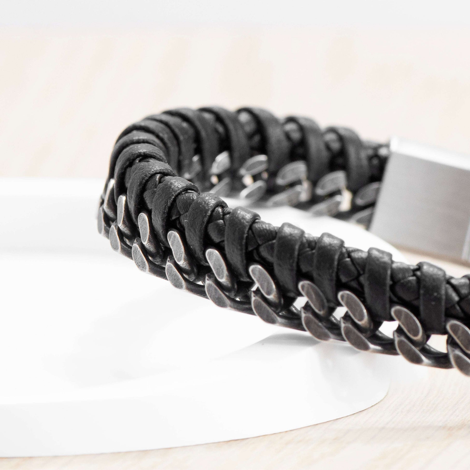 Black braided leather bracelet on a white surface