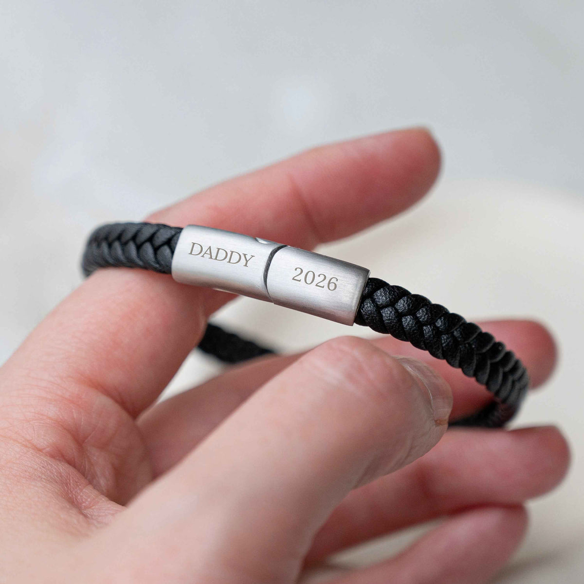 Personalized Jigsaw Clasp Woven Leather Bracelet engraved with the word 'DADDY' and the year '2026'.
