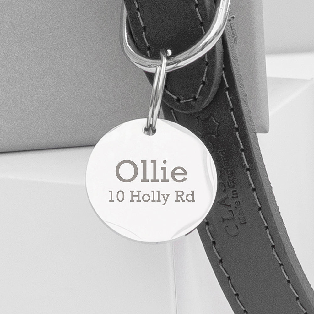 Dog tag with engraved name and address on a leather strap