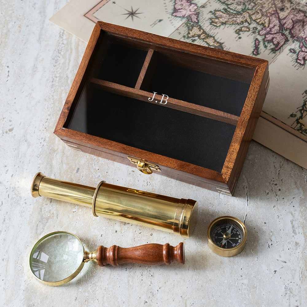 Personalized explorer gift set of together three  instruments—a working pocket compass, miniature extendable telescope, and scholar's magnifying glass—presented in a beautifully crafted wooden keepsake box.The top is engraved wi th personalized initials.