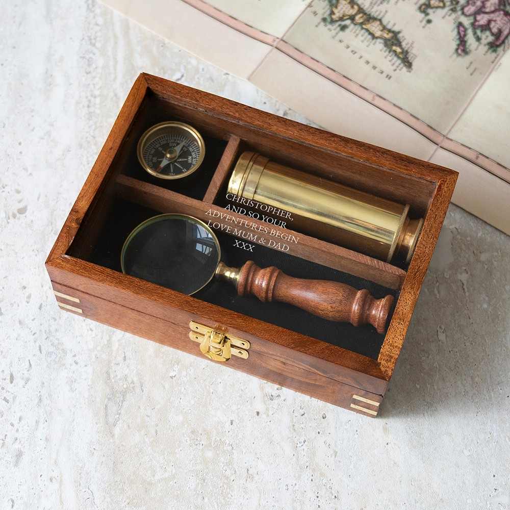 Personalized explorer gift set of together three  instruments—a working pocket compass, miniature extendable telescope, and scholar's magnifying glass—presented in a beautifully crafted wooden keepsake box.The glass top is engraved wi th a personalized message.