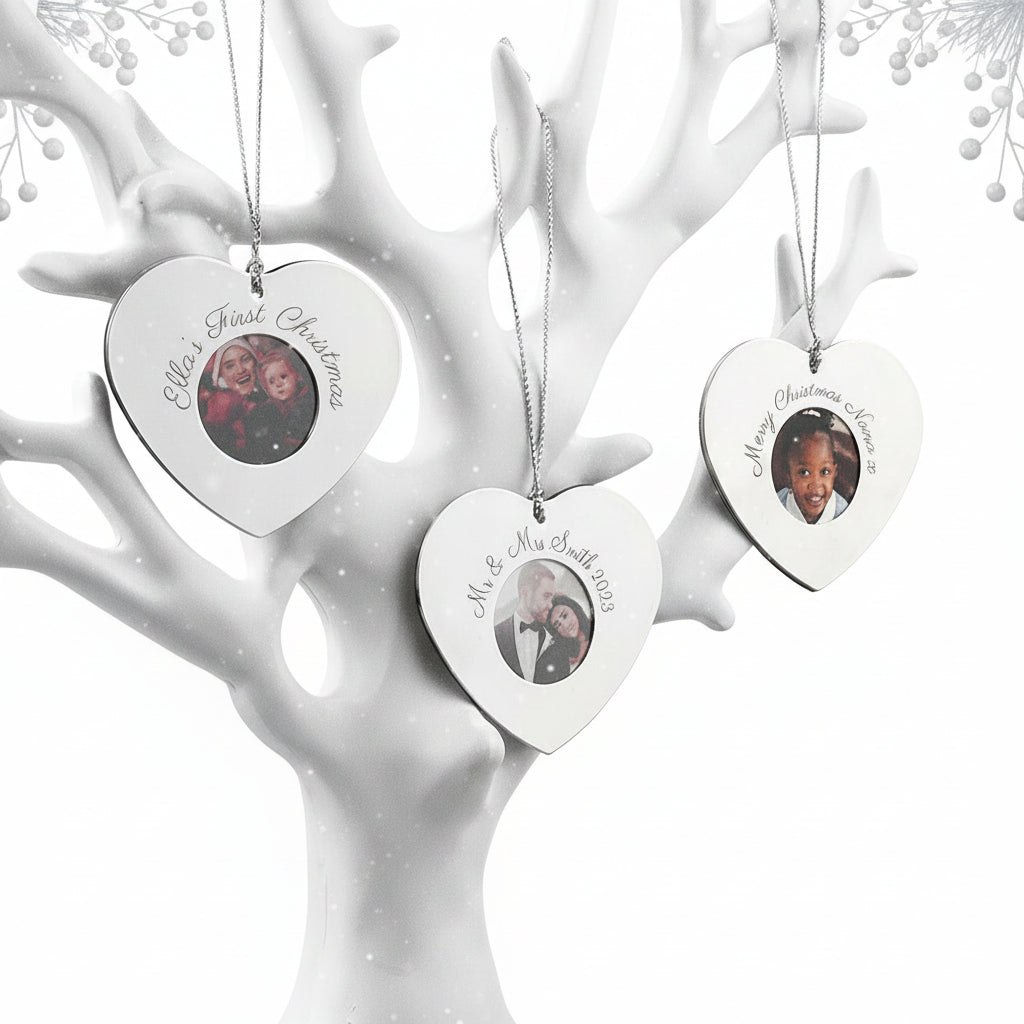 Heart-shaped photo ornaments on a white decorative tree with lights.