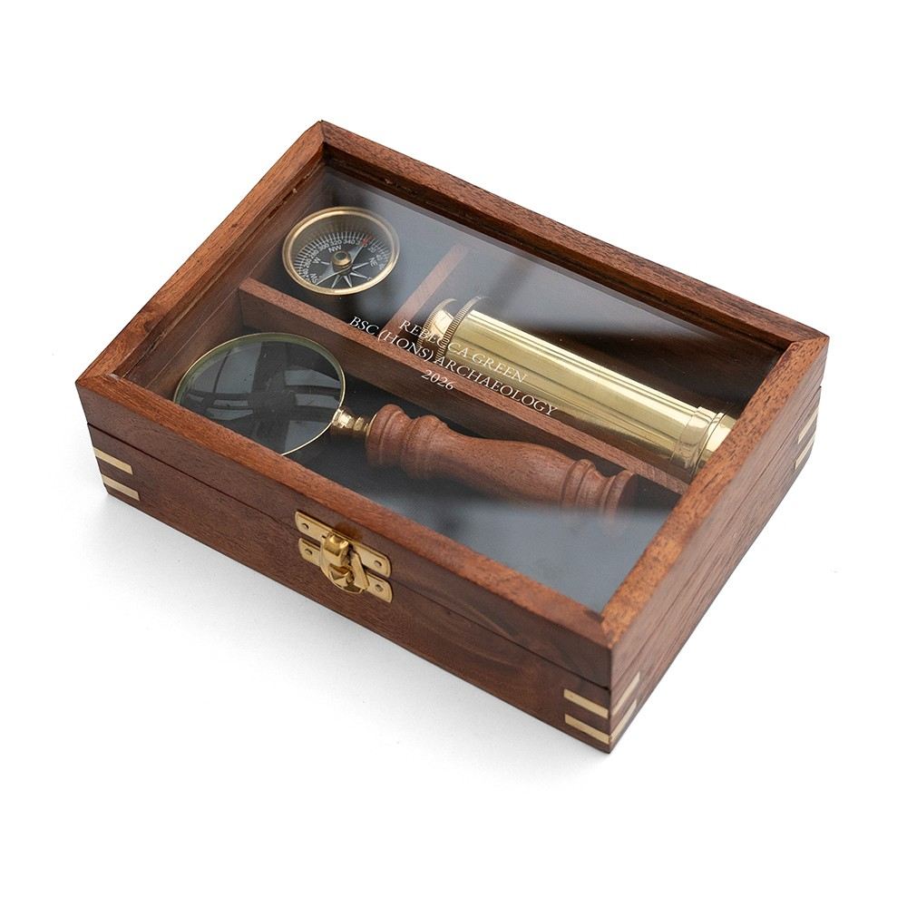 Personalized explorer gift set of together three  instruments—a working pocket compass, miniature extendable telescope, and scholar's magnifying glass—presented in a beautifully crafted wooden keepsake box.The top is engraved wi th a personalized graduation message.
