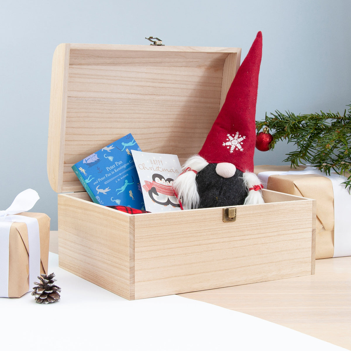 Wooden gift box with books and a gnome toy on a light blue background