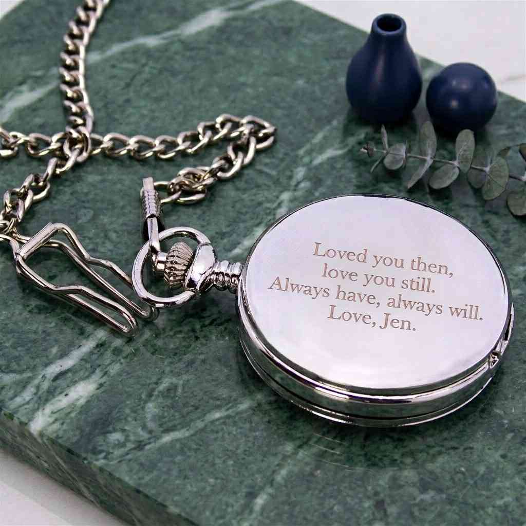 A silver pocket watch pendant necklace with an engraved message