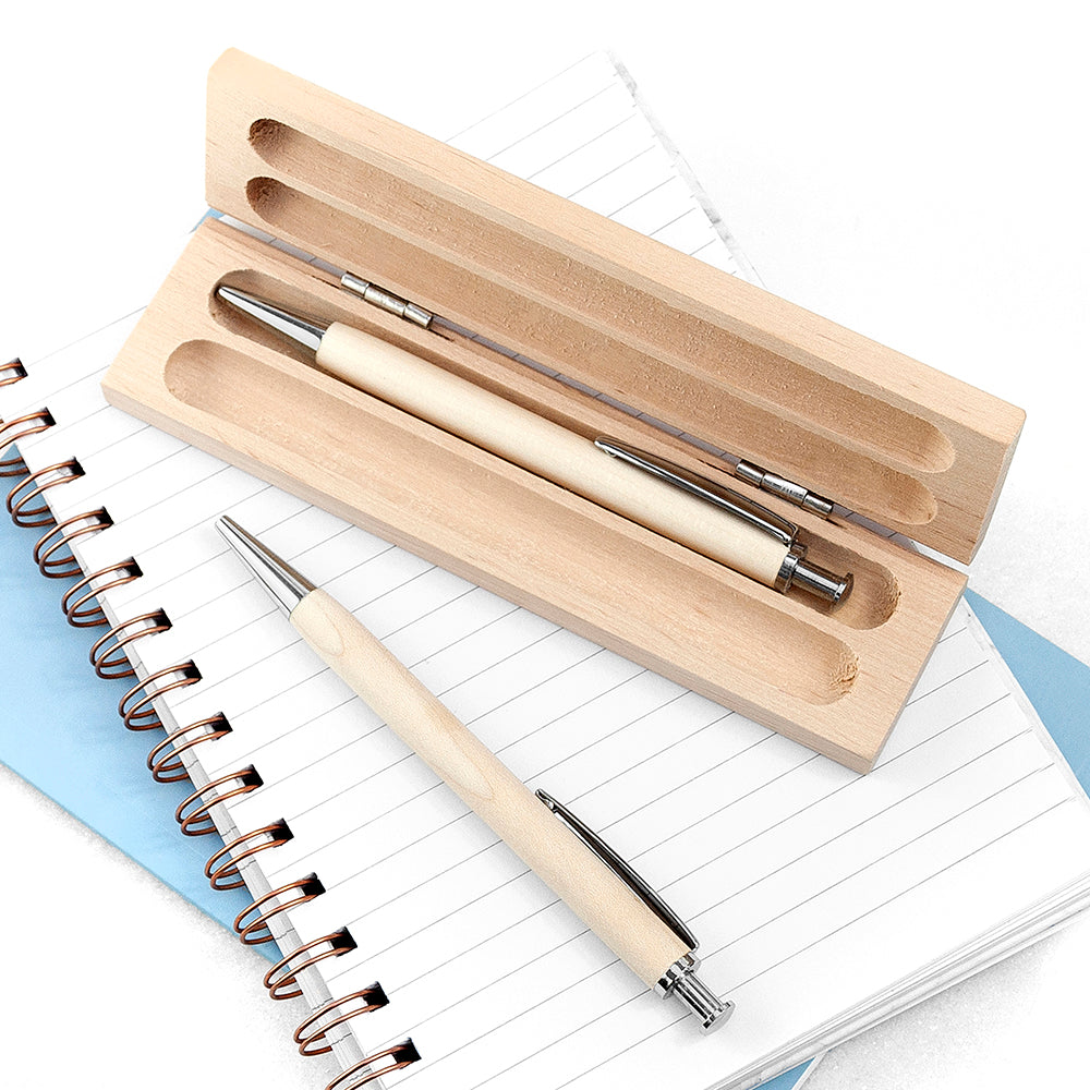 Set of pens with a wooden case on a notebook