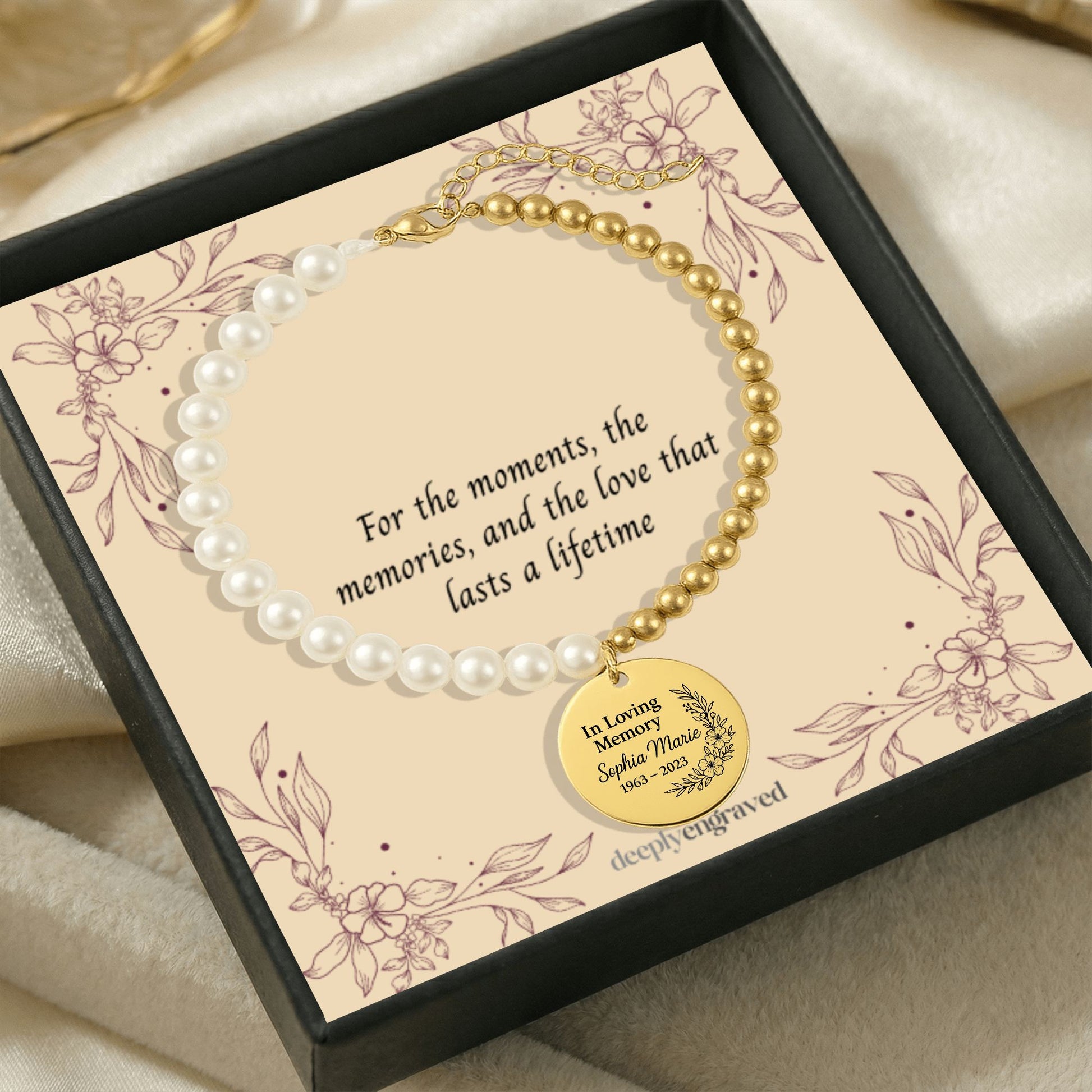 Pearl and gold bracelet with a commemorative charm on a decorative card.