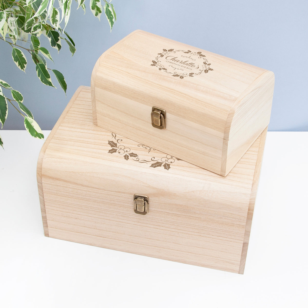 Two wooden boxes with engraved designs on a light background