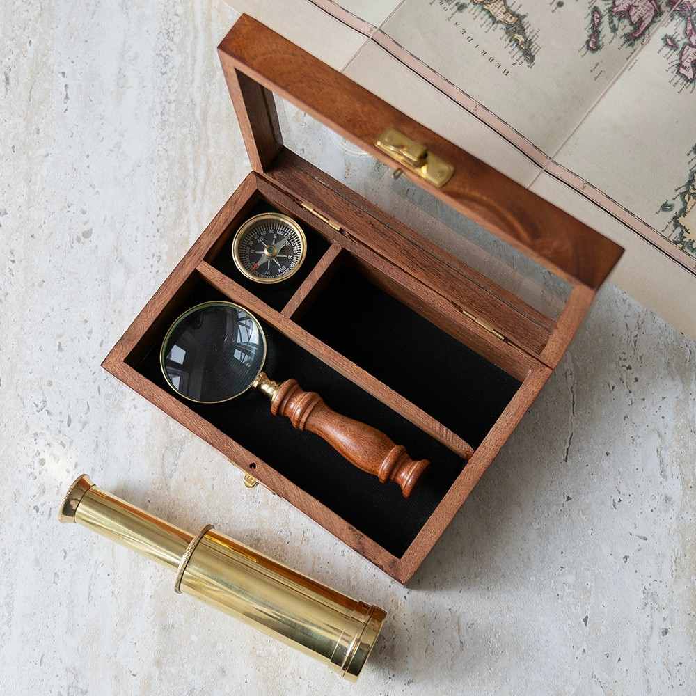 Personalized explorer gift set of together three  instruments—a working pocket compass, miniature extendable telescope, and scholar's magnifying glass—presented in a beautifully crafted wooden keepsake box.The top is engraved wi th a personalized message.
