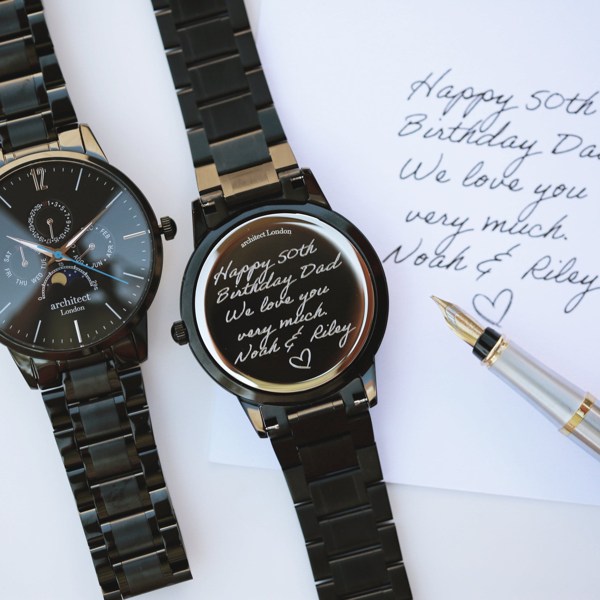Two black watches with engraved messages on a white background