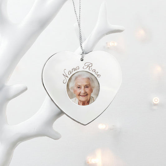 Heart-shaped ornament with a photo frame and engraved name, hanging on a white decorative branch.