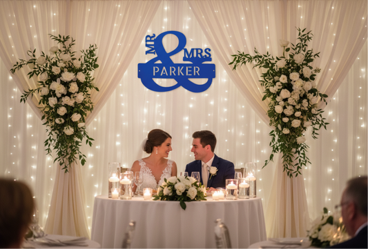 Personalized Mr. & Mrs. Ampersand Metal Wall Decor-Wedding couple at a decorated table with 'Mr & Mrs Parker' sign