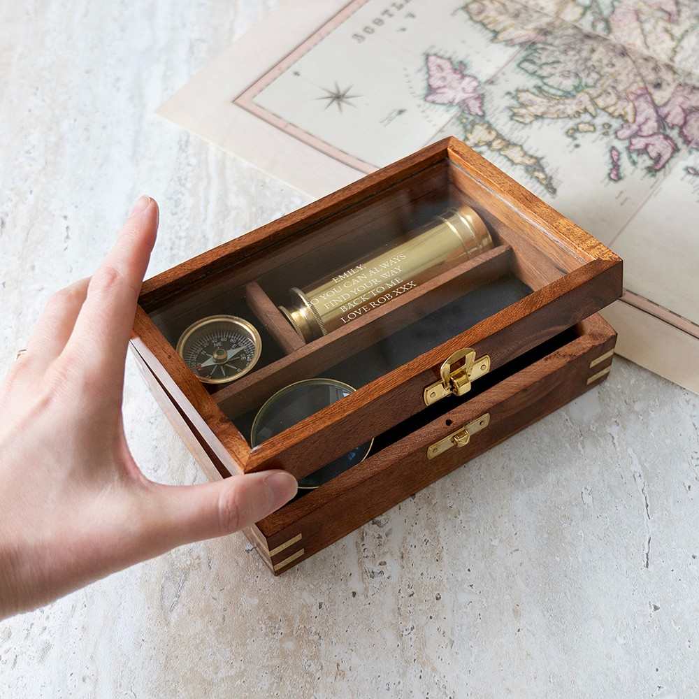 Personalized explorer gift set of together three  instruments—a working pocket compass, miniature extendable telescope, and scholar's magnifying glass—presented in a beautifully crafted wooden keepsake box. The glass top is engraved wi th a personalized message.