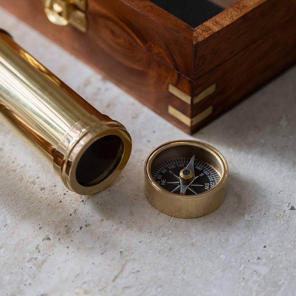 Personalized explorer gift set of together three  instruments—a working pocket compass, miniature extendable telescope, and scholar's magnifying glass—presented in a beautifully crafted wooden keepsake box.