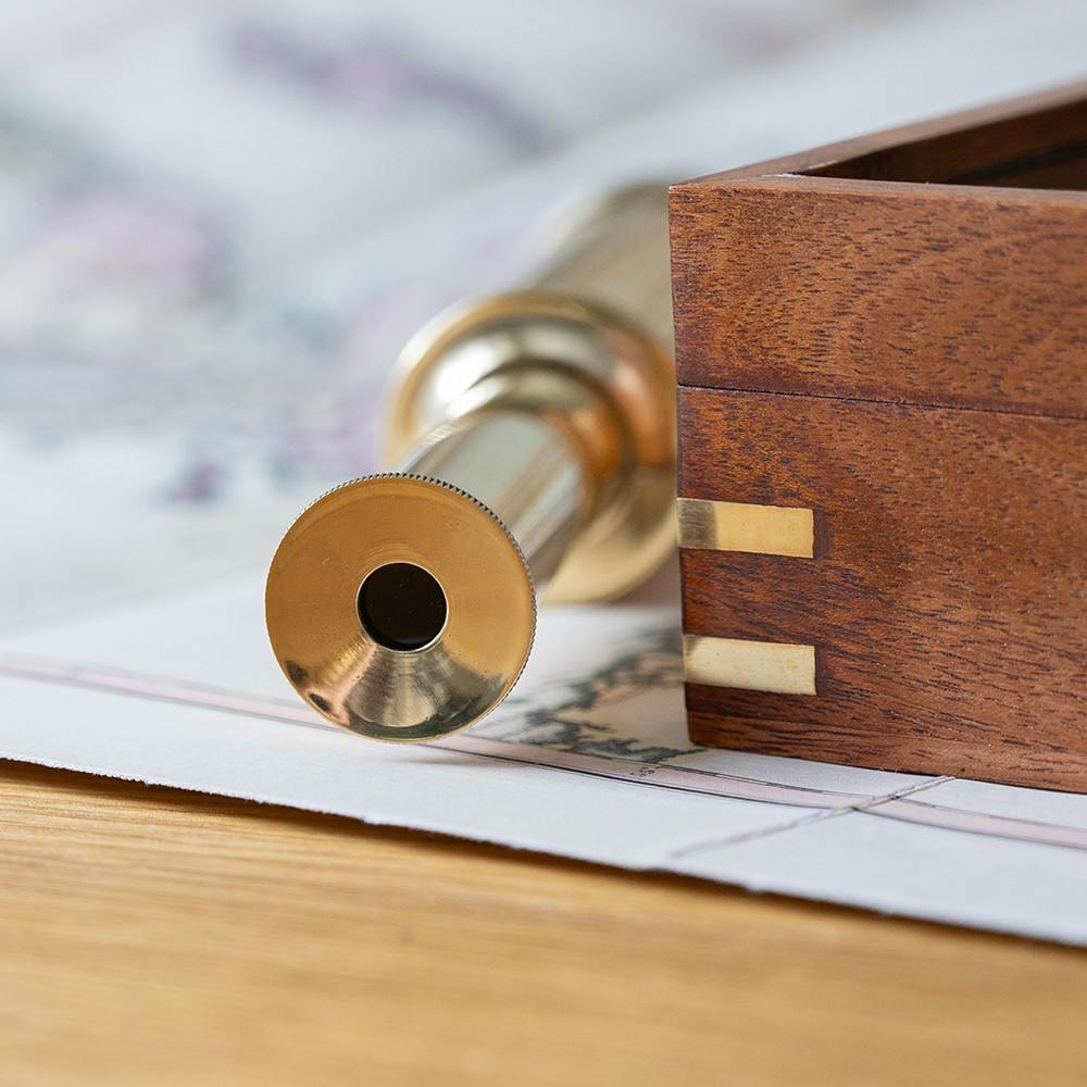 Personalized explorer gift set of together three  instruments—a working pocket compass, miniature extendable telescope, and scholar's magnifying glass—presented in a beautifully crafted wooden keepsake box.